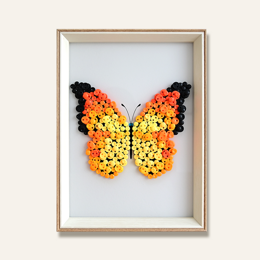 Orange Butterfly-shaped art made from the unique buttons in a wooden frame 