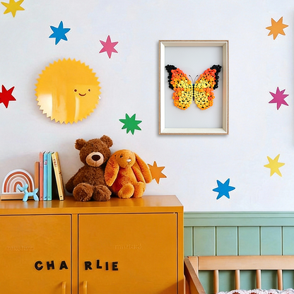Orange butterfly button art in a frame hangs on the wall.