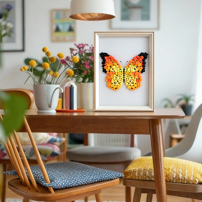 Orange butterfly button art in a frame on a shelf with other decorative items.